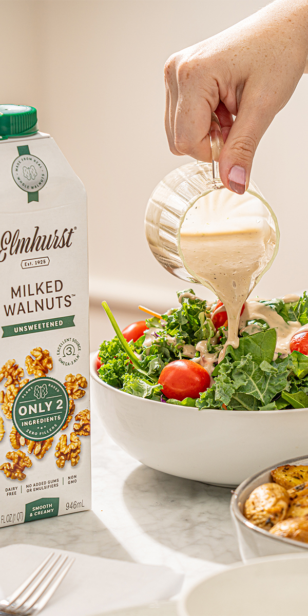 a bowl of salad with walnuts and vegan walnut vinaigrette dressing