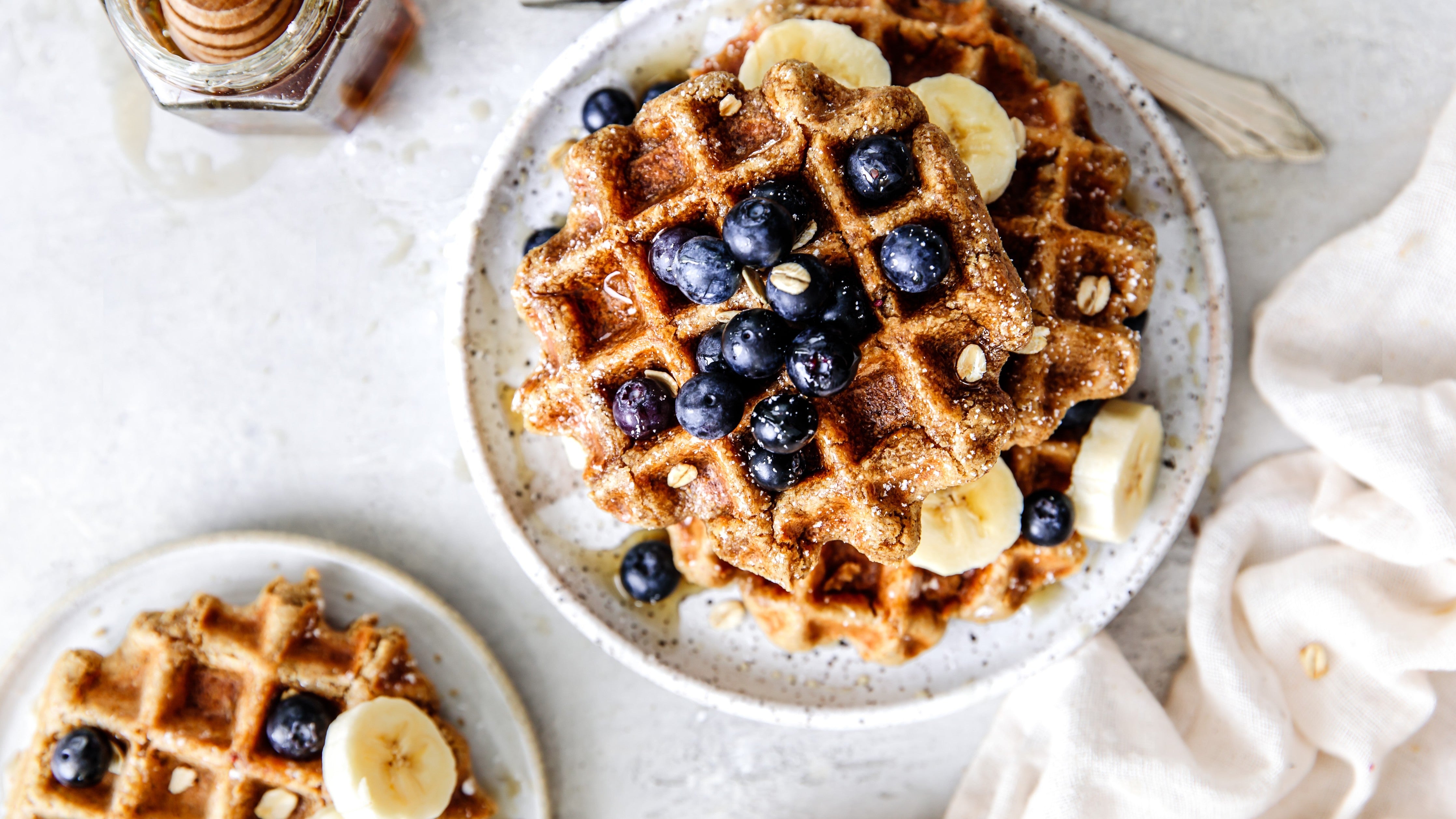 vegan and gluten free waffles topped with bananas and blueberries