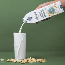 Pouring fresh, clean-ingredient cashew milk into a glass