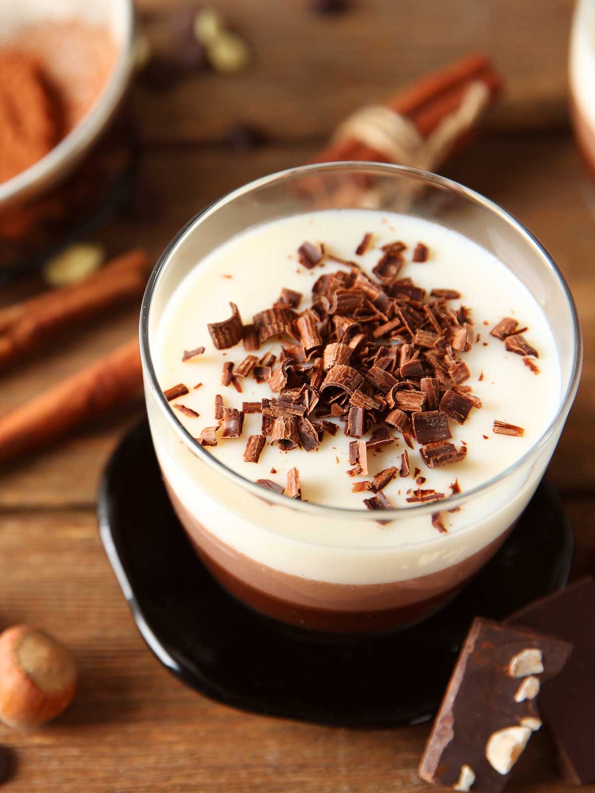 chocolate shavings on top of a glass of hot chocolate