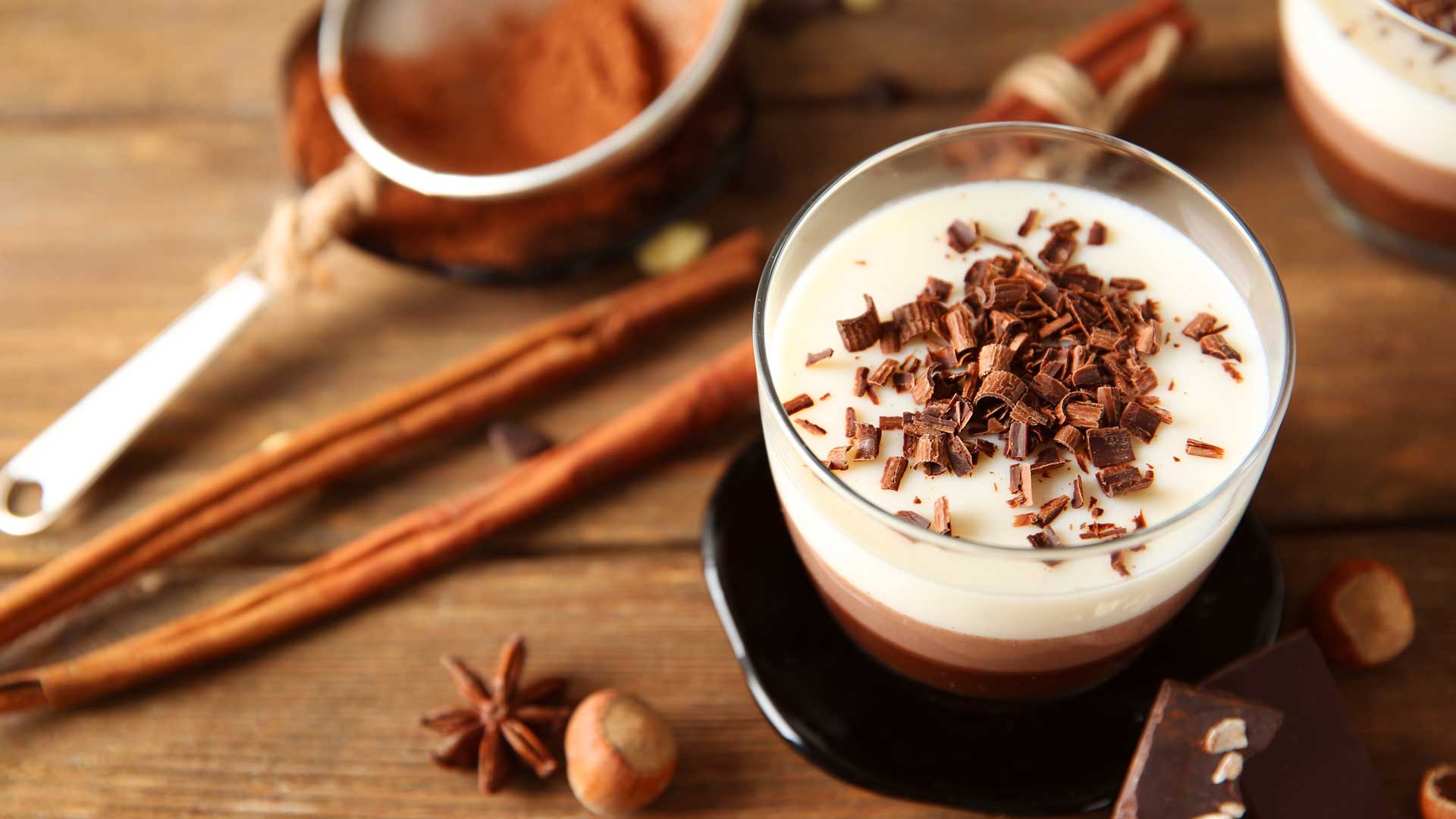 chocolate shavings on top of a glass of hot chocolate