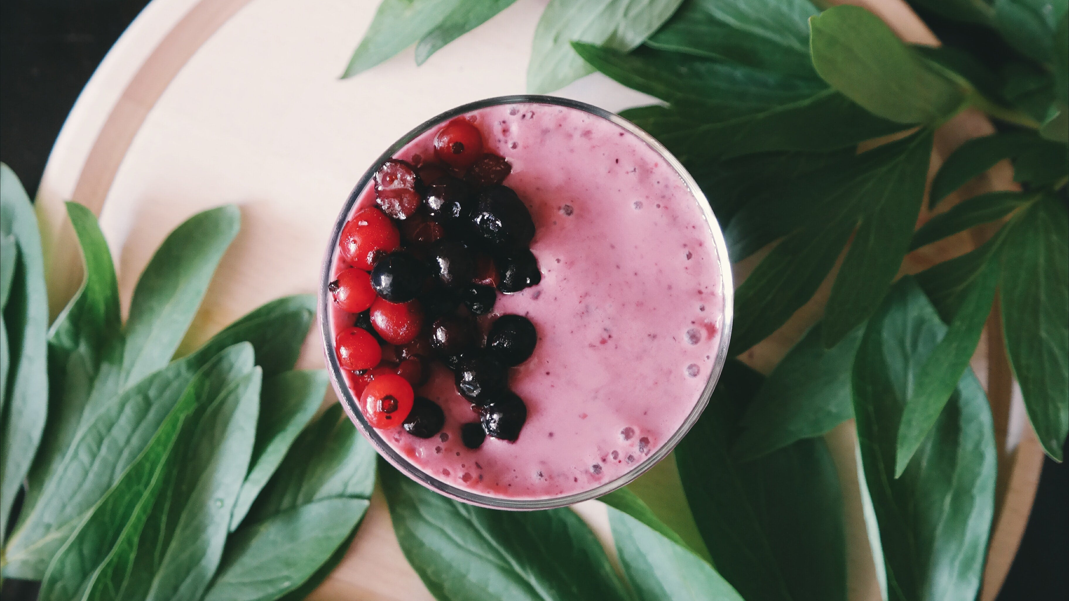 mixed berry smoothie with mixed berries on top made with plant milk