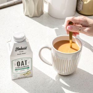 woman stirring her coffee after adding non-dairy oat milk creamer